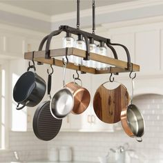 a pot rack with pots and pans hanging from it's ceiling in a kitchen