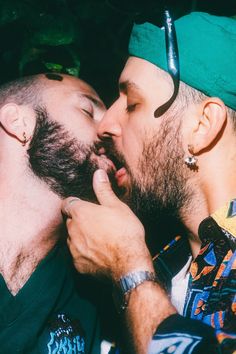 two men are kissing each other while wearing headgear and bandannas on their heads