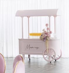 a pink ice cream cart with flowers on top