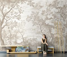 a woman sitting on a bench in front of a wall mural