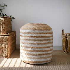 two woven baskets sitting on the floor next to each other, one with a plant in it