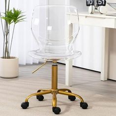 an office chair with wheels on the floor in front of a desk and potted plant