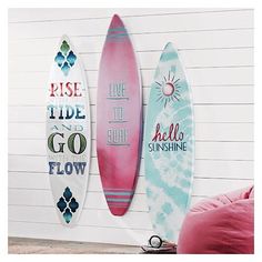 three surfboards mounted to the side of a wall