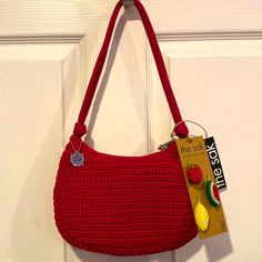 a crocheted purse hanging on a door handle with a tag attached to it