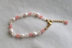 a bracelet with pearls and pink flowers on it