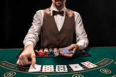 a man sitting at a table with cards in front of him and playing the game