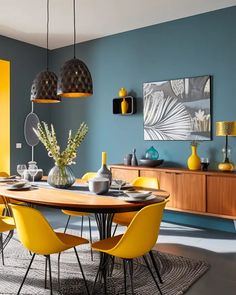 a dining room with blue walls and yellow chairs around the table in front of it