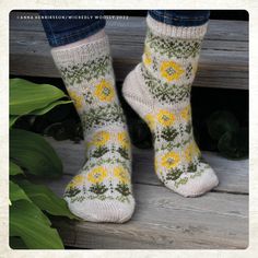 a woman's feet wearing socks with yellow flowers on them and green leaves in the background