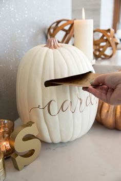 a white pumpkin with the word carara on it being held by someone's hand