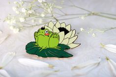 a green frog sitting on top of a flower next to some white flowers and leaves