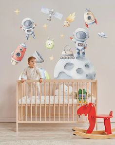 a baby in a crib with space themed wall decals