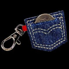 a coin is in the pocket of a blue jean keychain with a metal clip