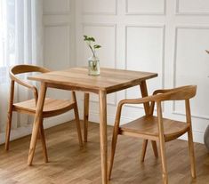 two chairs and a table in a room with white walls, hardwood floors and wood flooring