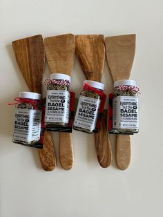 five wooden spoons with different types of spices on them next to some wood utensils