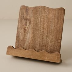 a wooden stand holding a piece of wood on it's back end, with wavy edges