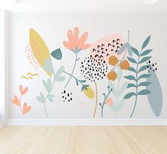 an empty room with flowers painted on the wall and wood flooring in front of it