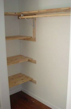 an empty closet with wooden shelves in it