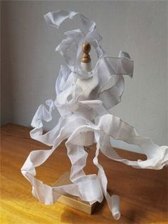 a white sculpture sitting on top of a wooden table