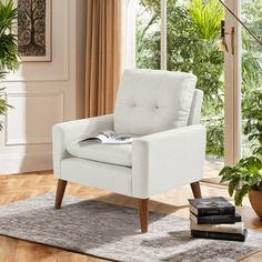 a white chair sitting on top of a wooden floor next to a potted plant