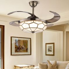 a living room with a white couch and ceiling fan in it's centerpiece