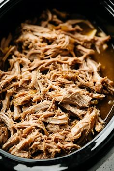 shredded pork in a slow cooker with sauce