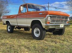 an orange and brown truck parked in the grass