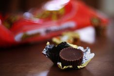 a chocolate bar sitting on top of a wooden table next to a bag of candy