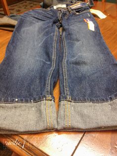 a pair of jeans sitting on top of a wooden table