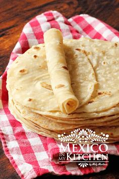 several tortillas on a red and white checkered napkin