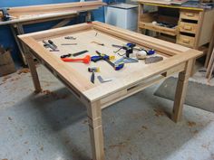 a wooden table with tools on it in a room