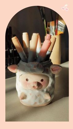 a piggy jar with pens and pencils in it