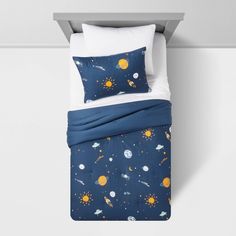 a bed with space themed sheets and pillows