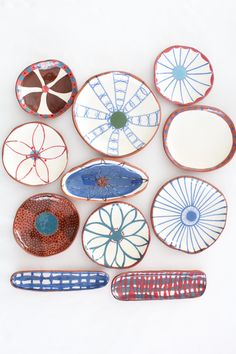 several plates are arranged in the shape of an abstract wheel on a white surface, with blue and red accents