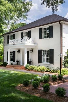 a large white house with black shutters on the front