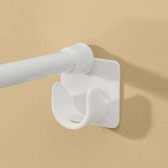 a white toilet paper dispenser mounted to the wall with a long handle