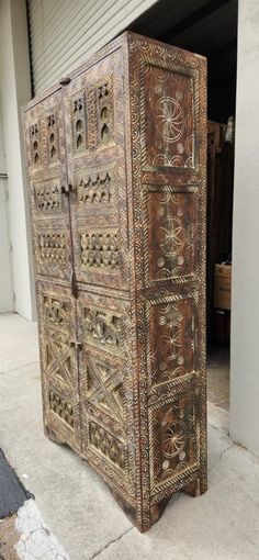 an old wooden cabinet sitting on the side of a building next to a garage door