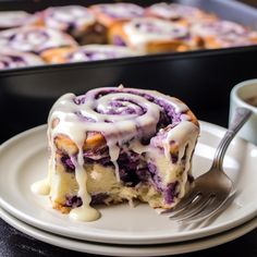 a white plate topped with blueberry cinnamon rolls