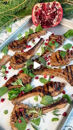 grilled steaks with fresh herbs and pomegranate on a platter