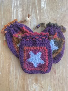 three crocheted bags sitting on top of a wooden table