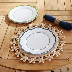 two plates sitting on top of a wooden table next to a blue and white napkin