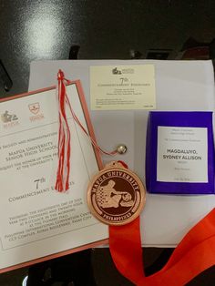 an award medal, certificate and other items on a table