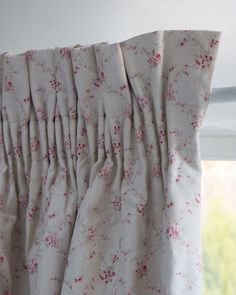 the curtain is pulled back and has pink flowers on it