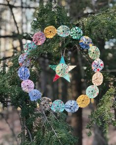 an ornament hanging from a tree in the woods with stars and circles on it