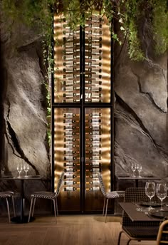 a restaurant with tables and chairs in front of a large window filled with wine bottles