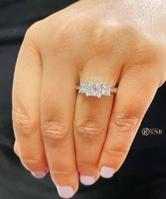 a close up of a person's hand with a diamond ring on their finger