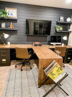 an office with two desks and a television mounted on the wall above it is shown