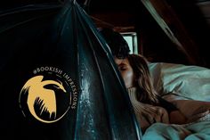 a woman laying in bed with an umbrella over her head and the bookish lakes logo on it