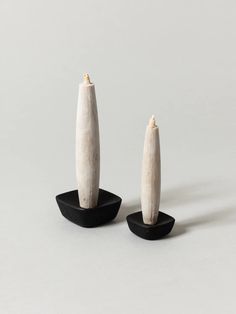 two white sculptures sitting on top of black bases