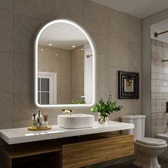 a bathroom with a sink, toilet and mirror in it's center piece is shown