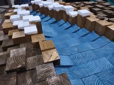 several pieces of wood sitting on top of a blue cloth covered table with white squares